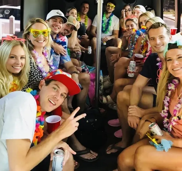 Friends celebrating with leis on board an Austin Party Bus between brewery stops