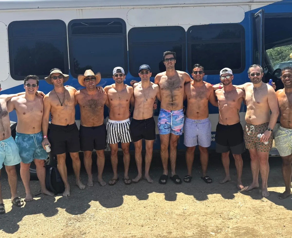 Group of guys posing outside their Austin party bus before a bachelor party day out