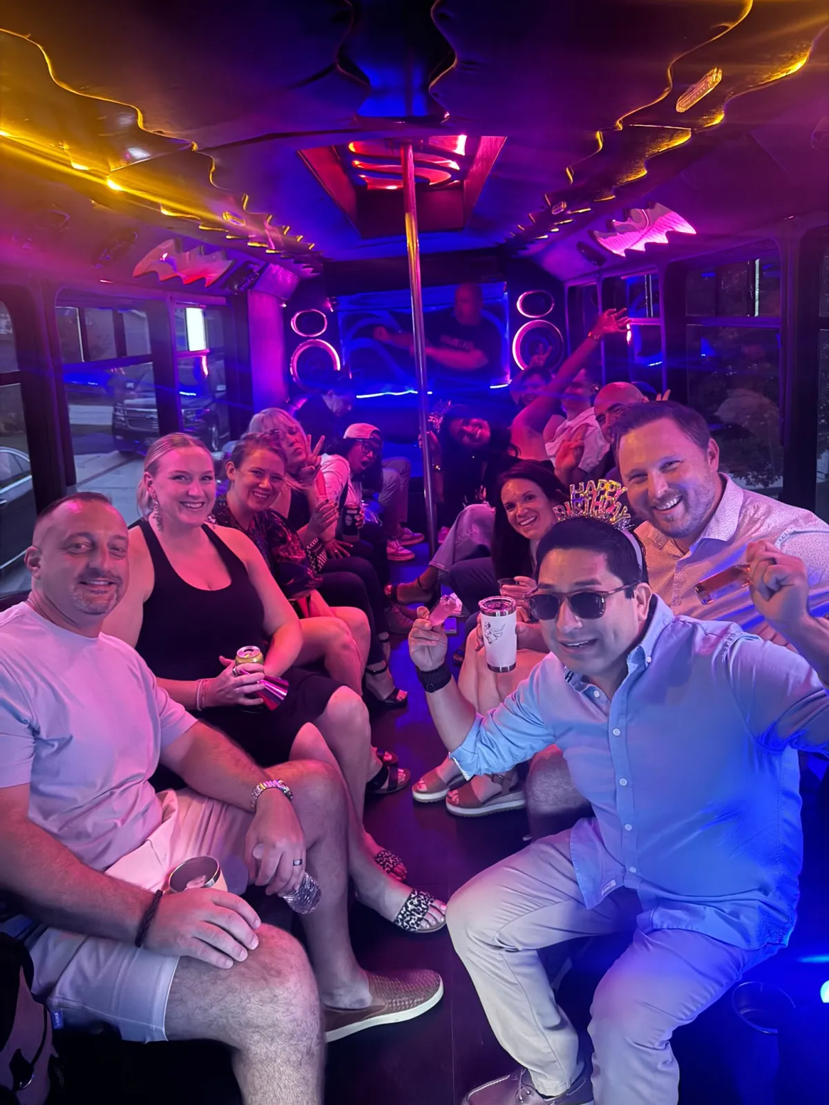 Birthday party group celebrating with drinks on an Austin party bus with LED lights