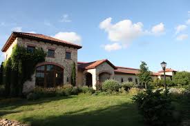 a large brick building with grass in front of a house